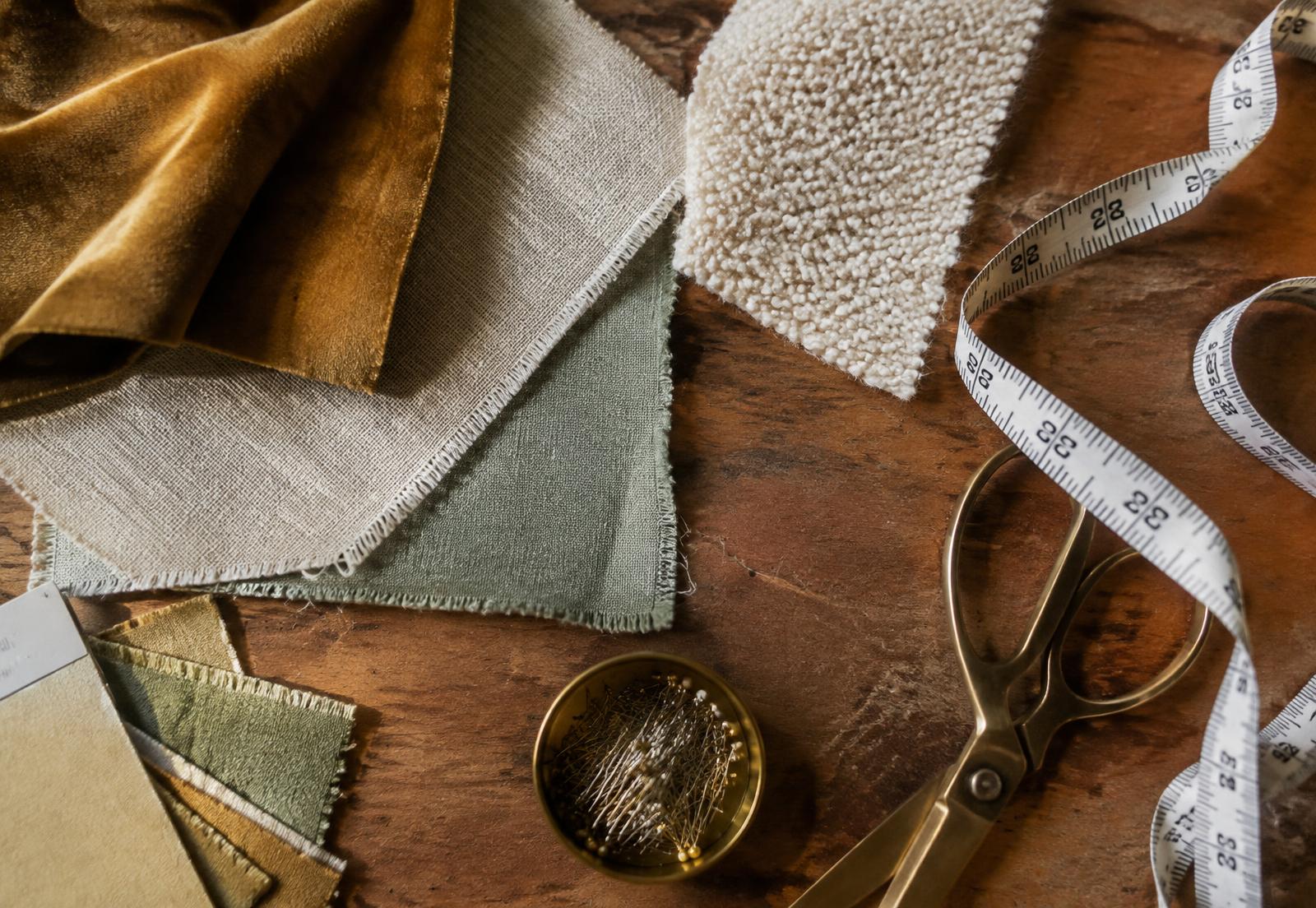 Fabric swatches, tape measure and brass scissors